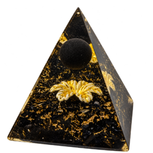 CHONIT Orgonit-Pyramide Schwarz-Gold mit schwarzer Kugel und goldfarbenem Blütenmotiv, freigestellt.